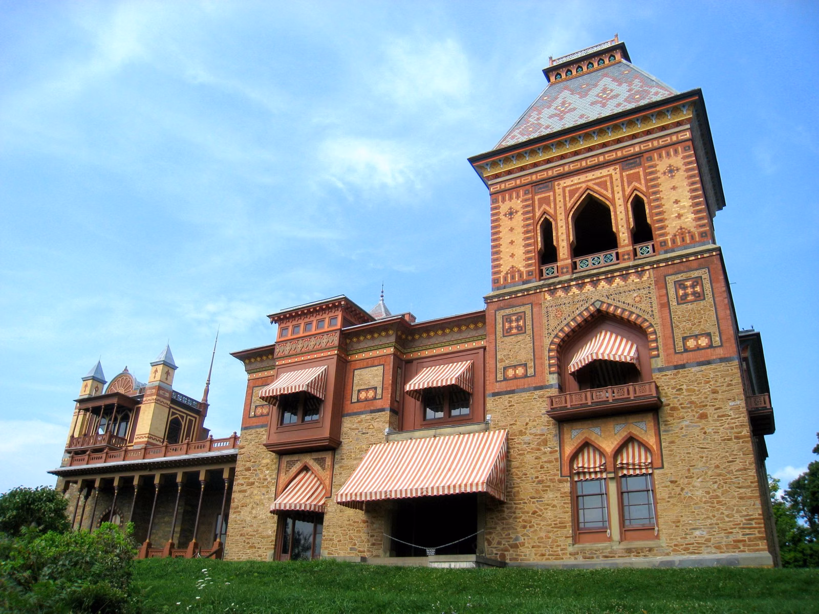 Olana's Persian-style mansion with its patterned brick tower and striped awnings under a blue sky